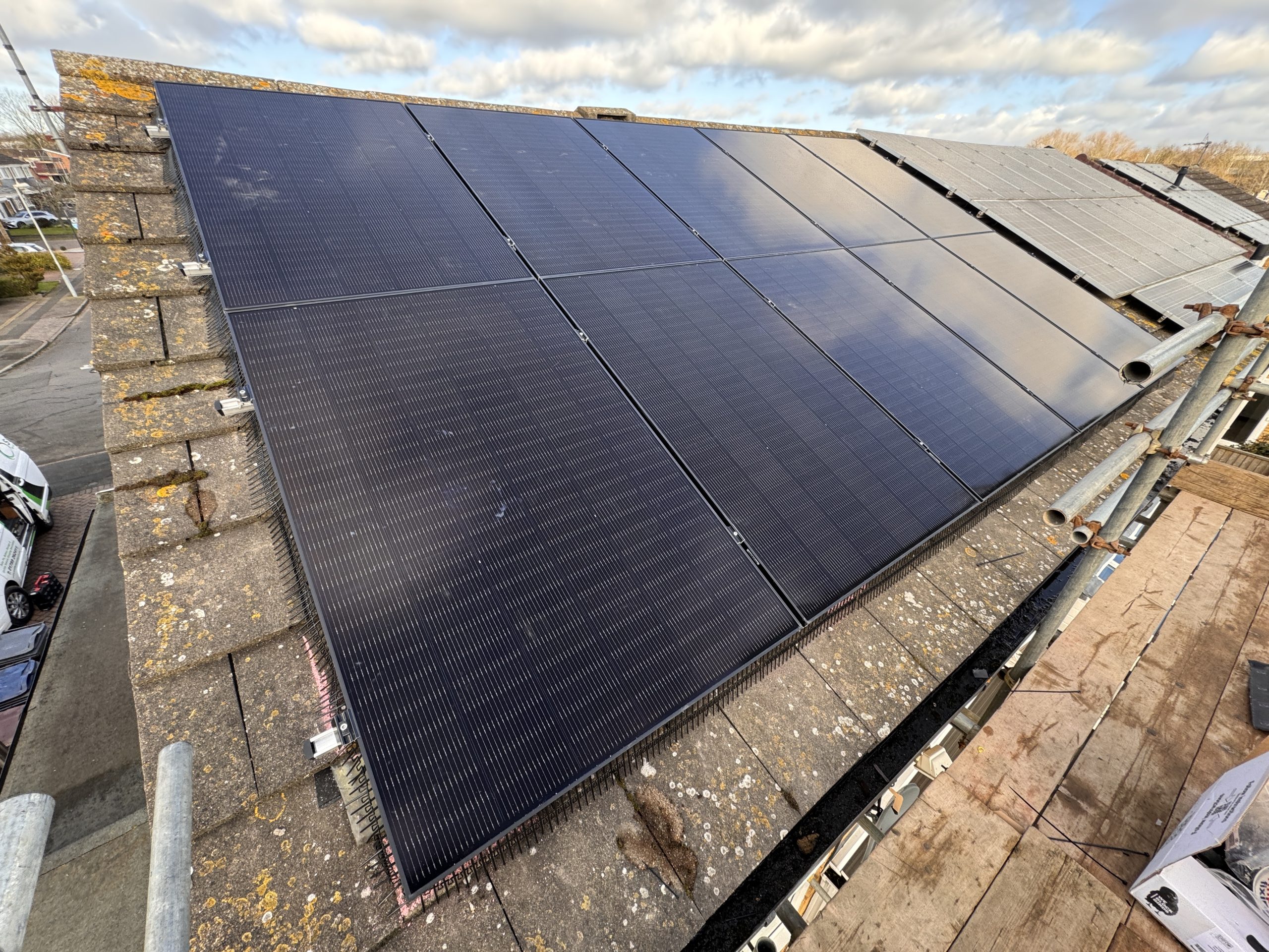 The Rowley family standing next to their newly installed solar panels on the roof of their Birmingham home.
